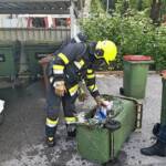 Feuerwehrmann mit ausgebrannten Mülleimer