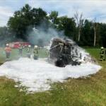 Rundballenpresse und Strohfeld in Flammen