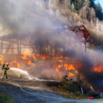 Wirtschaftsgebäude in Vollbrand wird von Feuerwehrleuten gelöscht