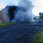 Feuerwehrleute löschen überhitzten Container