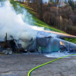 Wirtschaftsgebäude in Vollbrand wird von Feuerwehrleuten gelöscht