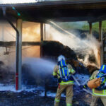Wirtschaftsgebäude in Vollbrand wird von Feuerwehrleuten gelöscht