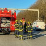 Feuerwehrleute stehen auf der autobahn neben einem Feuerwehrfahrzeug