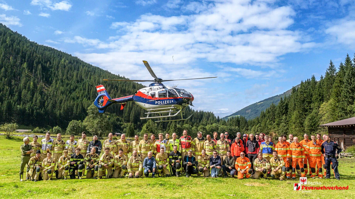 Gruppenfoto mit Hubschrauber bei Großübung gegen Vegetationsbrand im Zillertal