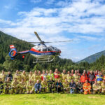 Gruppenfoto mit Hubschrauber bei Großübung gegen Vegetationsbrand im Zillertal