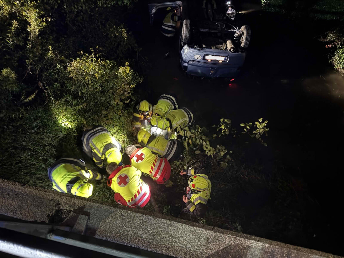 PKW landet im Bach, Person eingeklemmt