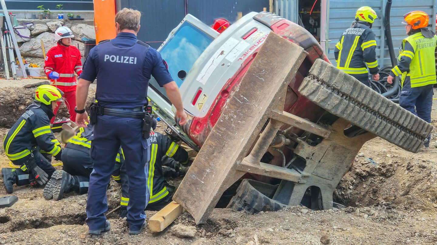 Person unter Bagger eingeklemmt