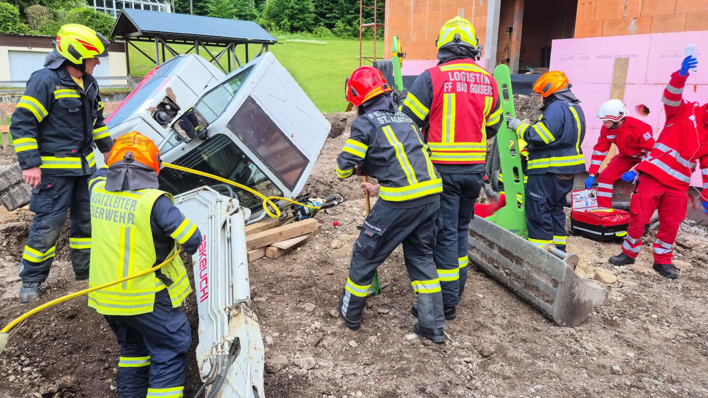 Person unter Bagger eingeklemmt
